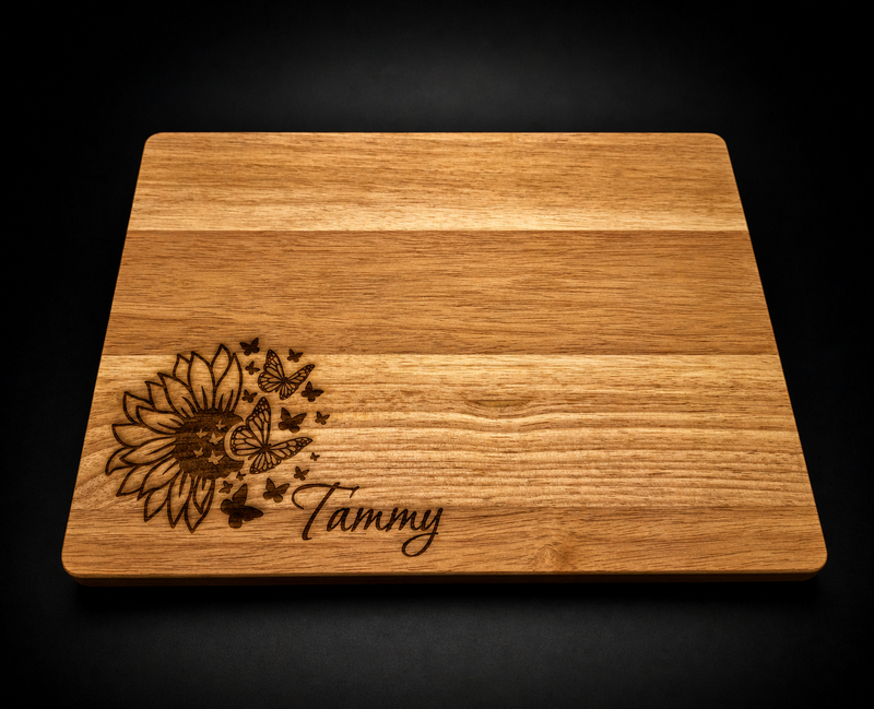 Wooden cutting board with engraved design and 'Tammy' text on a black background