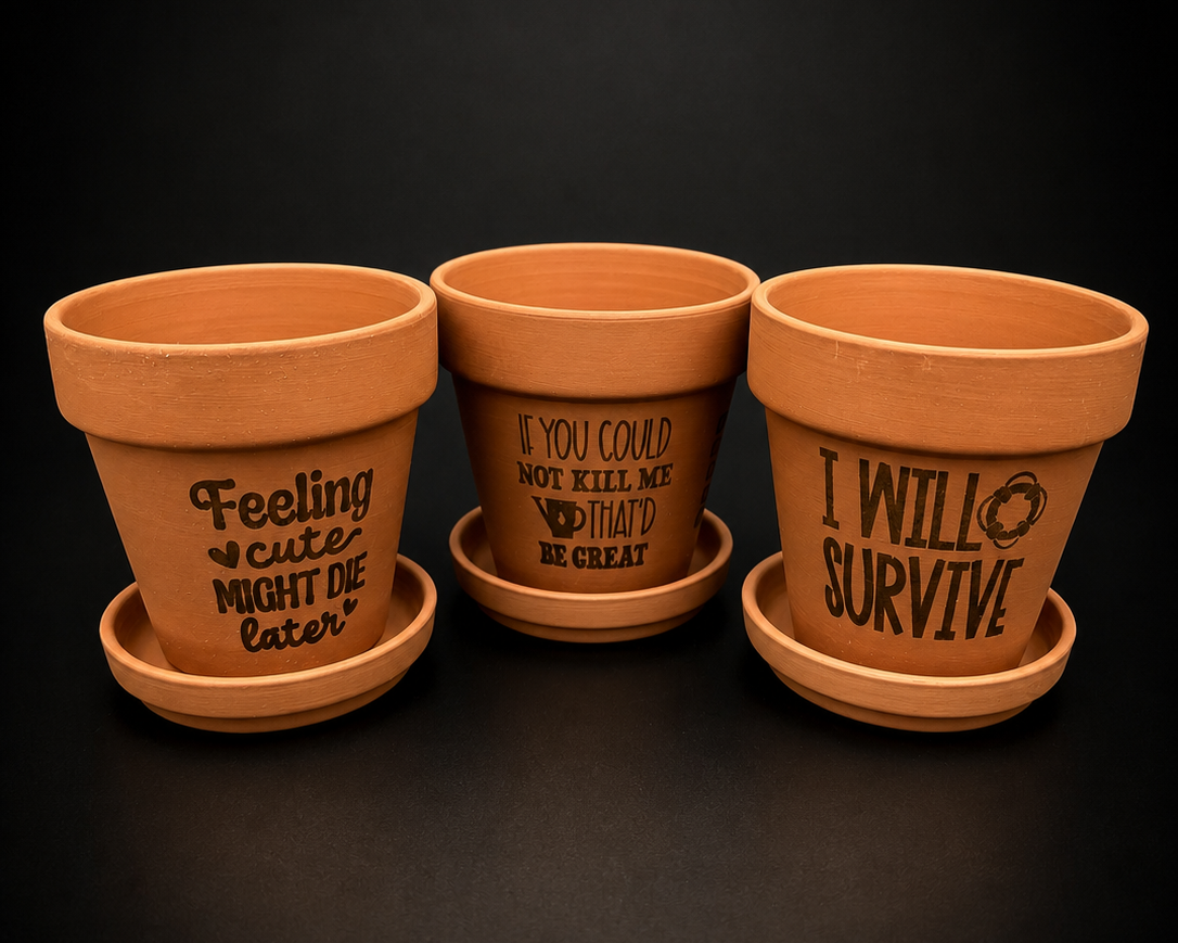 Three terracotta pots with engraved text on a black background